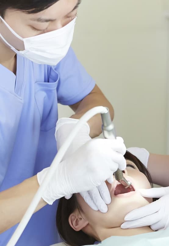 歯の治療を施す歯科医